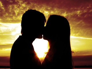 Couple kissing sunset sky clouds - a couple kissing in front free wallpaper