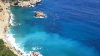 Beach cliff blue water rock - a view of a beach free wallpaper