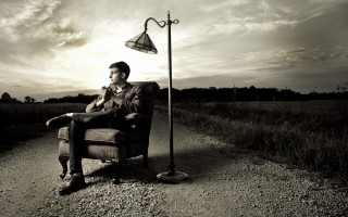 Man chair lamppost dirt road - a cloudy sky in the background free wallpaper