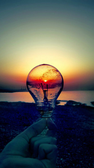 Hand lightbulb sunset water background - the sun free wallpaper