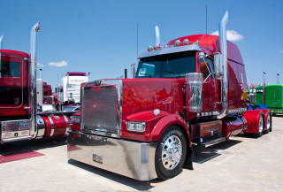 Red semi truck lot sunny - a red semi truck free wallpaper