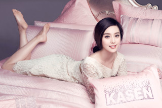 Woman laying bed pink sheets - a pink pillow free wallpaper