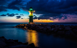 Lighthouse rocky shore night mystical - a body of water below free wallpaper