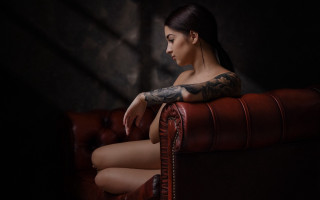 Tattooed woman red couch dark - a red couch free wallpaper