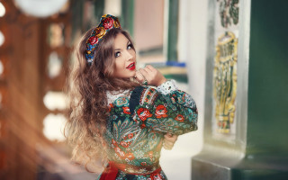 Woman colorful dress long hair - leaning against a wall free wallpaper