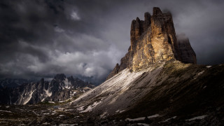 Mountain rock formation cloudy sunset - a dark sky above free wallpaper