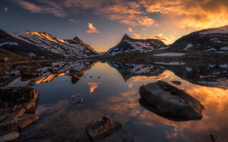 Mountain lake rocks sunset clouds - the foreground and a sunset in the background free wallpaper
