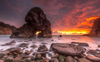 Rocky beach sunset formation campfire - a rock formation in the middle of it free wallpaper