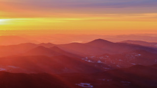 Mountain range sunset plane view 2 - a view of a mountain range free wallpaper