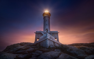 Lighthouse rocky hill bright light - the top of it free wallpaper