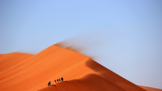 Desert dune group walking sunset - a photo free wallpaper