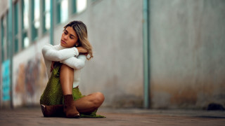 Woman sitting crossed arms building - a building in the background free wallpaper