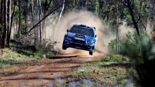 Blue car jumping dirt road - a photo free wallpaper