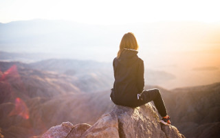 Woman sitting valley mountains sunset - sunrise free wallpaper