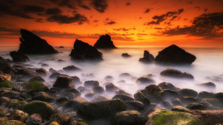 Rocky beach sunset water mountains 2 - a sunset in the background free wallpaper