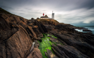 Lighthouse rocky cliff green stream - a cloudy day free wallpaper