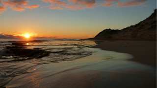 Sunset ocean rocky shore beach - a sunset over the ocean free wallpaper
