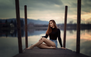 Woman dock sitting water cloudy - her leg free wallpaper