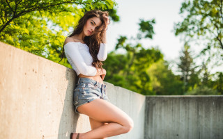 Woman leaning wall crossed legs 3 - livia prima free wallpaper