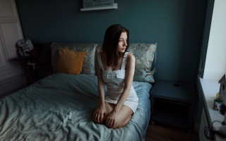 Woman sitting bed blue wall 3 - a blue wall free wallpaper