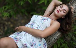 Woman laying tree branch dress - her arm behind her head free wallpaper