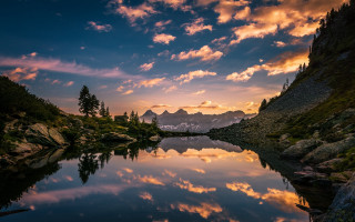 Lake mountains trees sunset cloudy 4 - mountain and trees under a cloudy sky free wallpaper