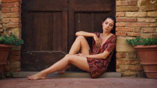 Woman sitting olive skin barefoot - the ground in front free wallpaper
