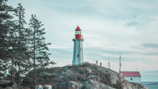 Lighthouse rocky outcropping red roof - a lighthouse free wallpaper