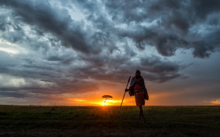 Person walking field umbrella sunset - a cloudy sky in the background free wallpaper