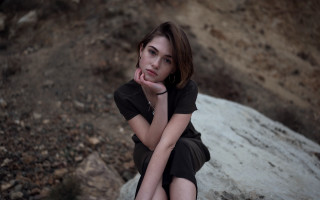 Woman sitting rock serious portrait - serious free wallpaper for desktop
