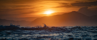 Sunset ocean wave mountains boat - a sun setting free wallpaper