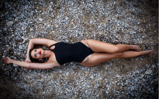 Woman black swimsuit rocky laying - andrea orcagna free wallpaper