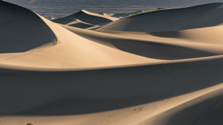 Sand dunes water skyline land - the background and a sky line in the foreground free wallpaper