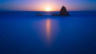 Rock ocean sunset bright sky - a bright sun in the background free wallpaper