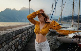 Woman yellow top dock mountains - a mountain range in the background free wallpaper