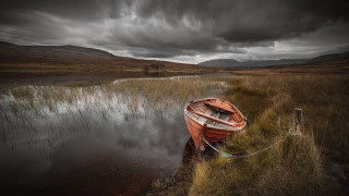 Boat water cloudy mountains sunset - water under a cloudy sky free wallpaper