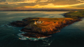 Lighthouse island ocean sunset clouds 2 - radiant free wallpaper