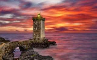 Lighthouse rock wall sunset clouds - a rock wall free wallpaper