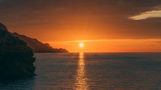 Sunset ocean boat mountain city - a sunset over the ocean free wallpaper