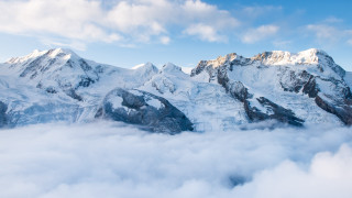 Snowy mountain range blue sky 15 - cloud below free wallpaper