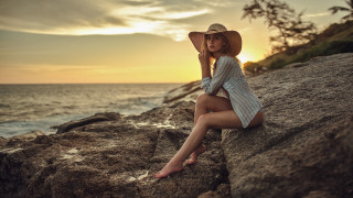 Woman sitting rock ocean sunset 2 - a rock near the ocean free wallpaper