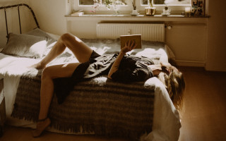 Woman reading book bedroom window - warm free wallpaper