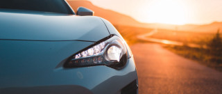 Car headlight sunset ocean mountain - neoism free wallpaper