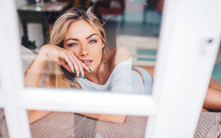 Woman couch window hand chin - natural light free wallpaper