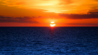 Sunset ocean boat distant city - a sunset over the ocean free wallpaper