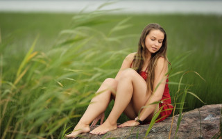 Woman sitting rock field cellphone - free bikini wallpaper