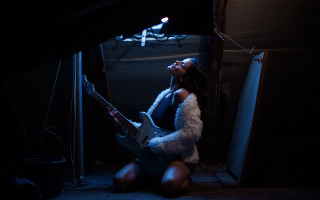 Woman playing guitar dark room - a guitar free wallpaper
