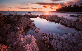 Sunset rocky beach water fence - a sunset over a rocky beach free wallpaper