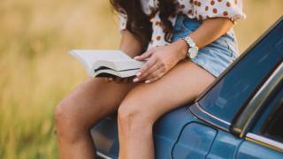 Woman sitting on car reading - the car free wallpaper