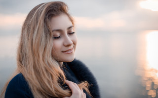 Woman longhair water smiling cellphone - a blurry background free wallpaper